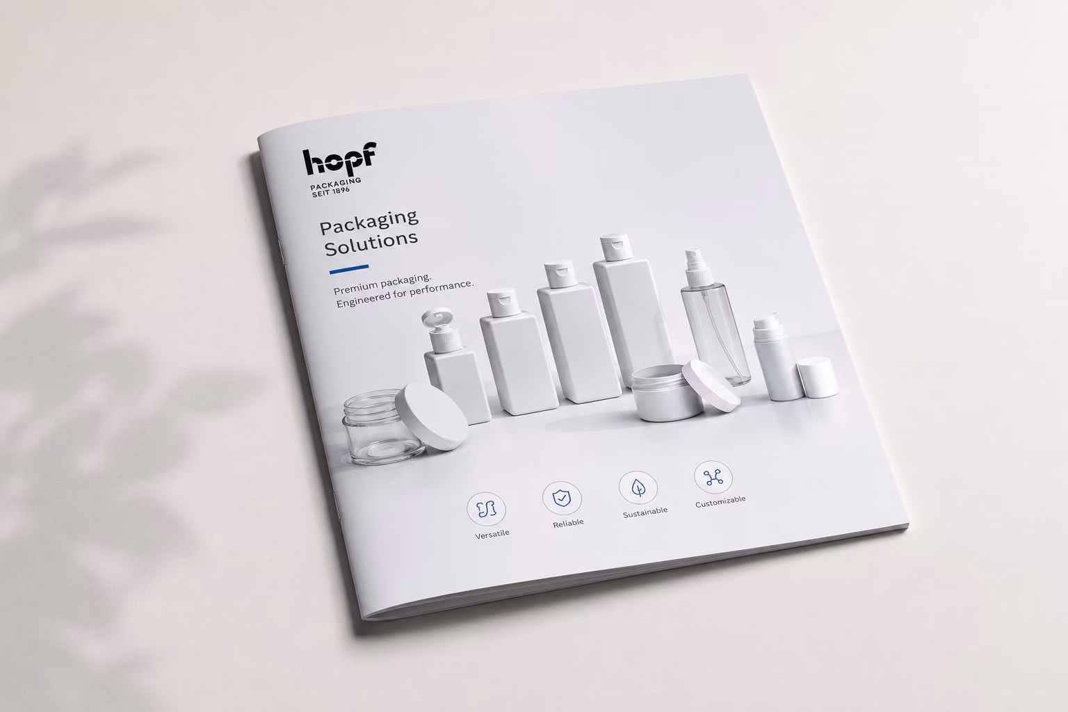 Hopf Packaging Broschüre „Packaging Solutions“ mit Produktfotos und Service-Icons auf hellem Untergrund mit Blattschatten