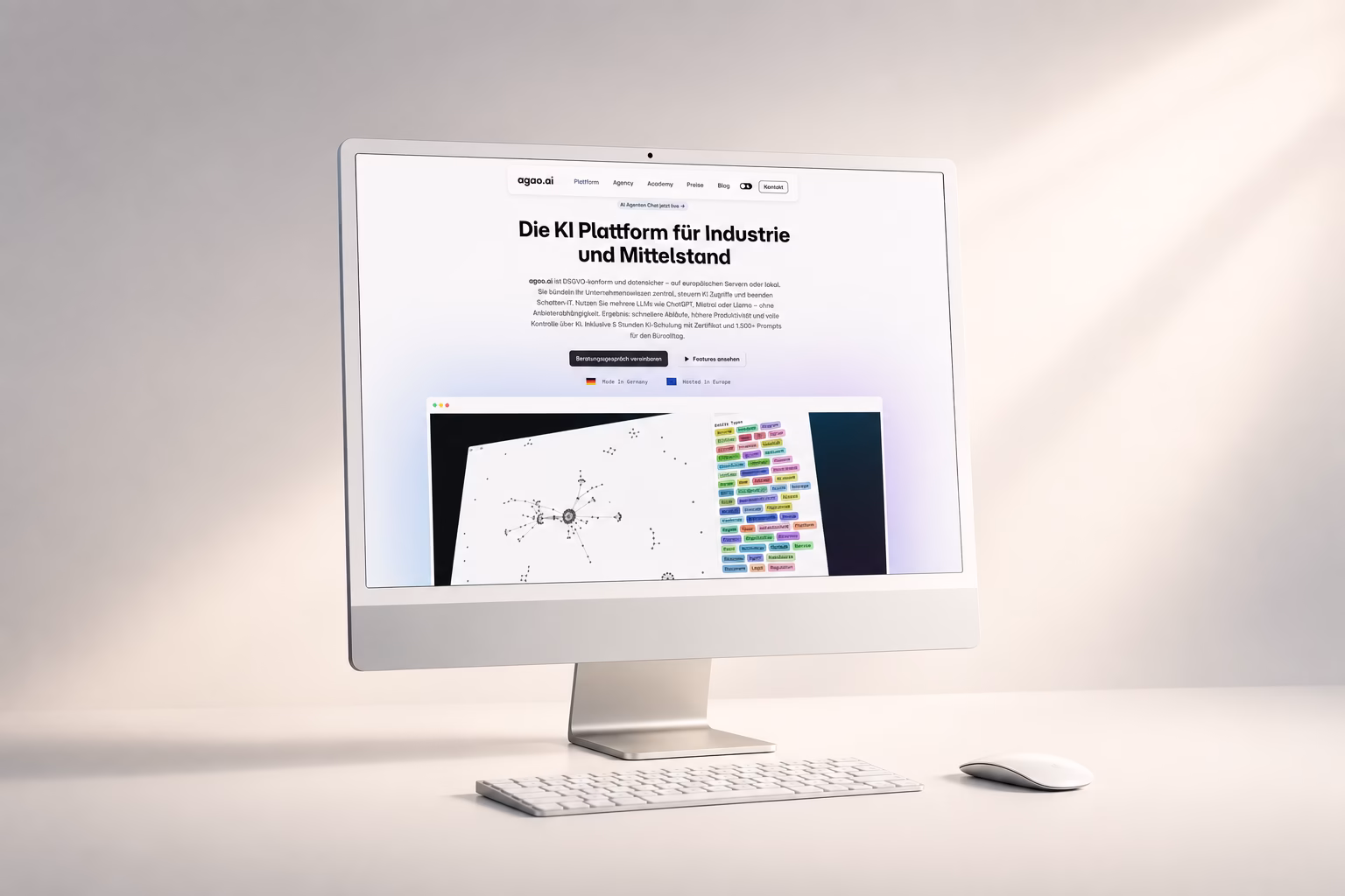 Silberner iMac zeigt die agao.ai-Website: Hero „Die KI Plattform für Industrie und Mittelstand“ mit Software-Preview, Tastatur und Pflanze